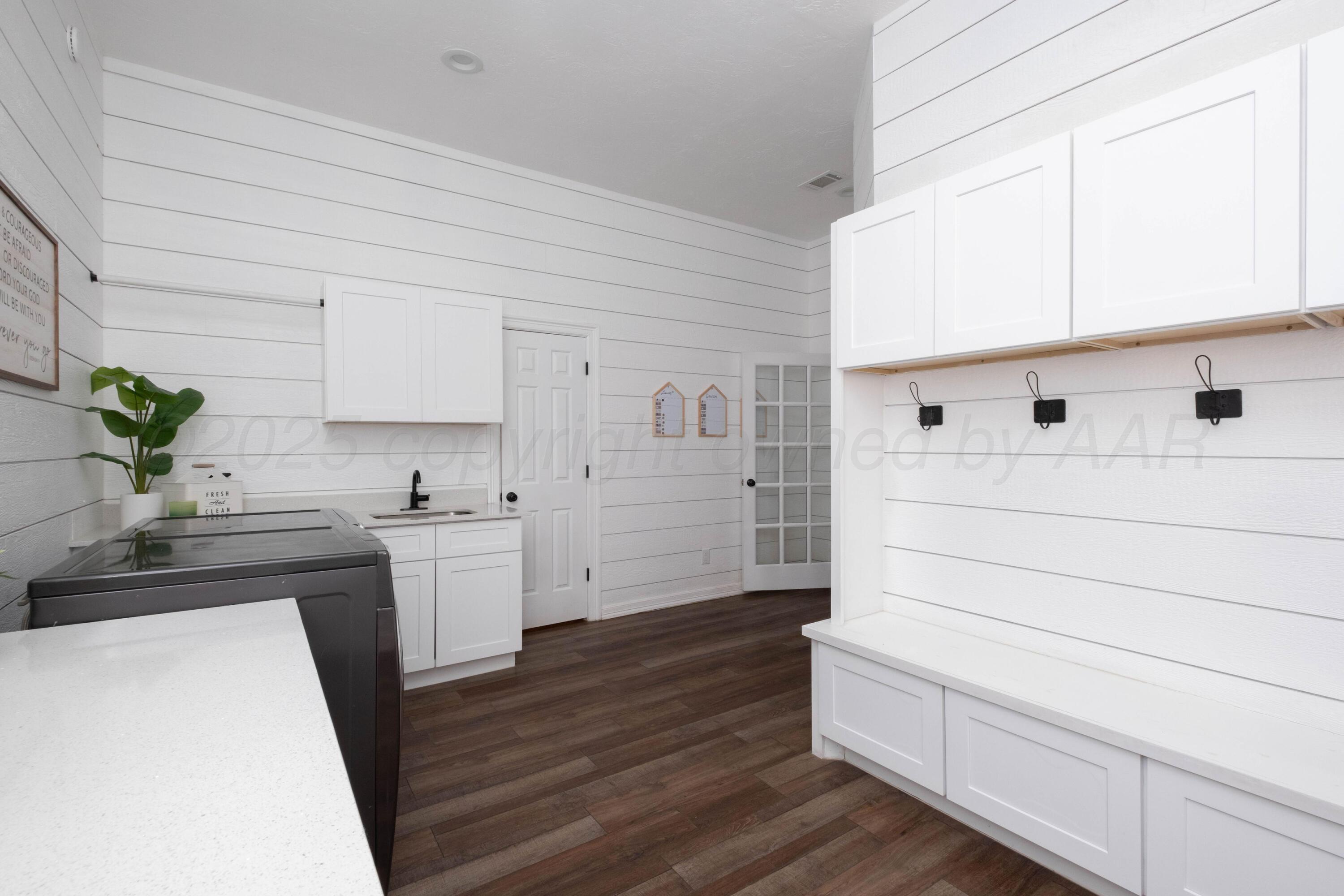 3207 Parker Street Amarillo, TX 79109 - Photo 67 of 73 a kitchen with white cabinets and wooden floor