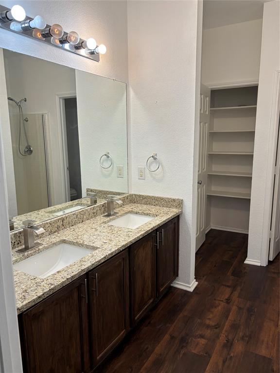6546 Portside Ridge Lane Dallas, TX 75249 - Photo 15 of 35 Full bathroom with a shower, a sink, toilet, and wood finished floors