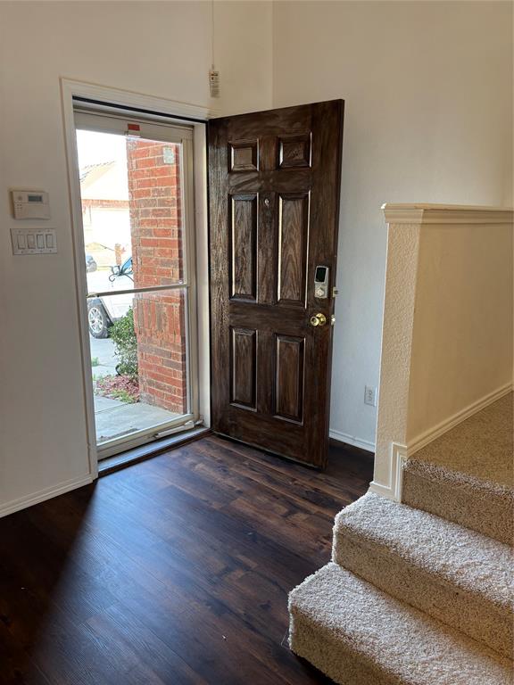 6546 Portside Ridge Lane Dallas, TX 75249 - Photo 27 of 35 Entrance foyer featuring dark wood-style flooring, baseboards, and stairway