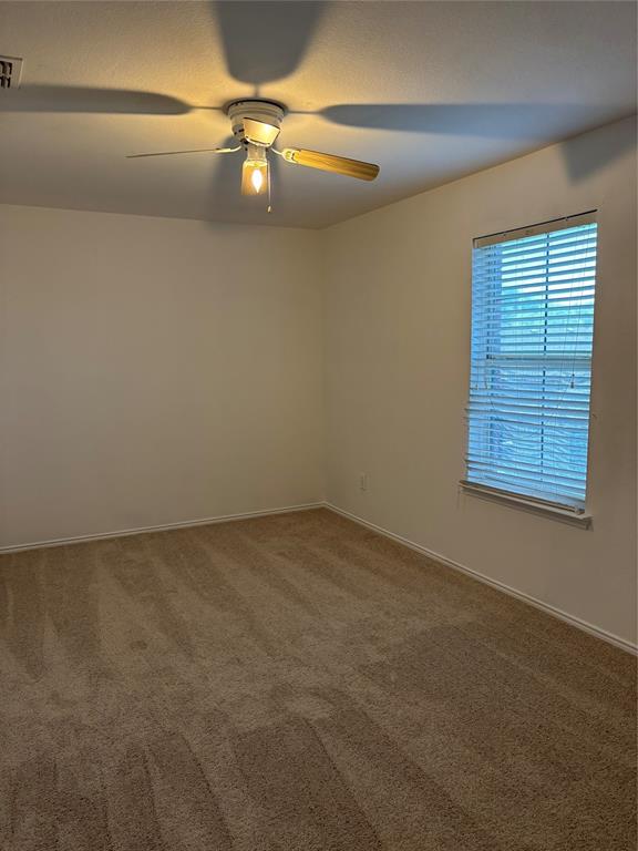 6546 Portside Ridge Lane Dallas, TX 75249 - Photo 3 of 35 Unfurnished room featuring baseboards, a ceiling fan, and carpet floors