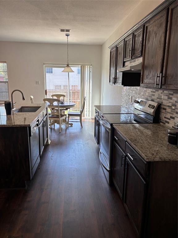 6546 Portside Ridge Lane Dallas, TX 75249 - Photo 32 of 35 Kitchen featuring range, range hood, dishwasher, a sink, and decorative backsplash
