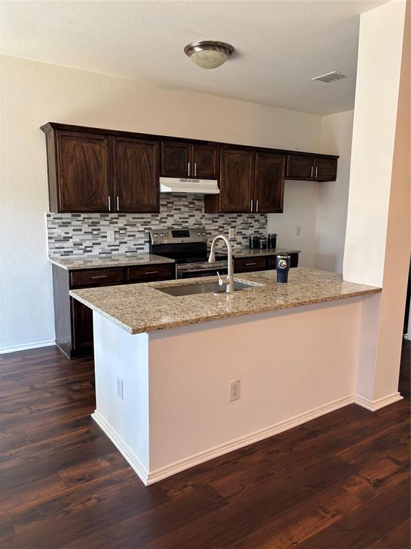 6546 Portside Ridge Lane Dallas, TX 75249 - Photo 33 of 35 Kitchen featuring exhaust hood, light stone countertops, electric range, visible vents, and a sink