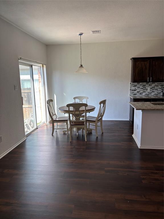6546 Portside Ridge Lane Dallas, TX 75249 - Photo 35 of 35 Dining room featuring visible vents, baseboards, and dark wood-style floors