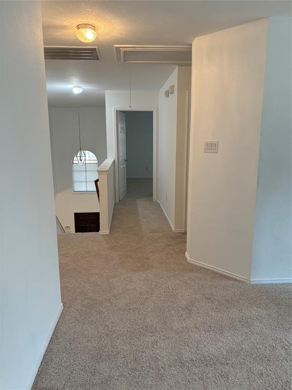 6546 Portside Ridge Lane Dallas, TX 75249 - Photo 5 of 35 Hall with baseboards, an upstairs landing, attic access, visible vents, and carpet
