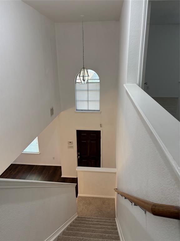 6546 Portside Ridge Lane Dallas, TX 75249 - Photo 6 of 35 Stairs with baseboards, wood finished floors, a towering ceiling, and visible vents
