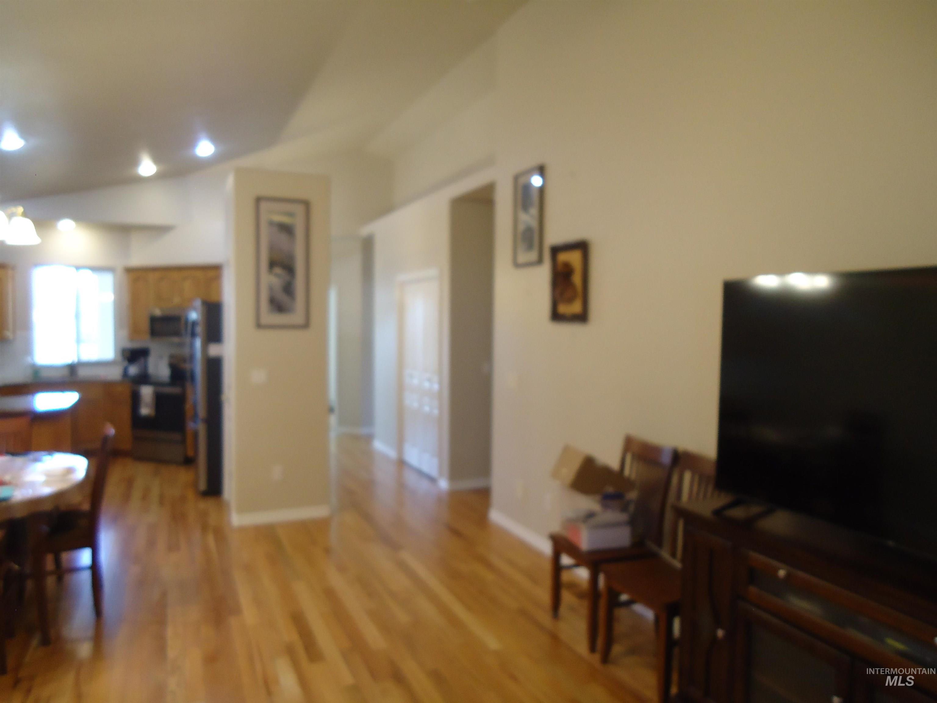 2734 North Turnberry Way Meridian, ID 83646 - Photo 5 of 18 Living area featuring lofted ceiling, light wood-style floors, and recessed lighting