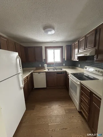 a kitchen with a sink a refrigerator a window and cabinets