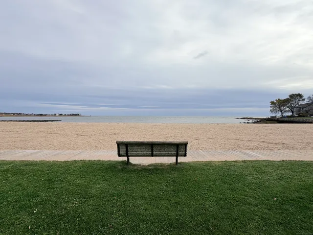 a view of a lake with a yard and wooden fence
