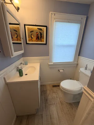 a bathroom with a toilet a sink and mirror