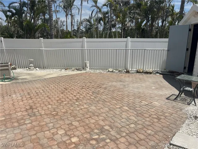 a view of a yard with wooden fence