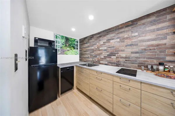 a kitchen with stainless steel appliances kitchen island a refrigerator sink and cabinets