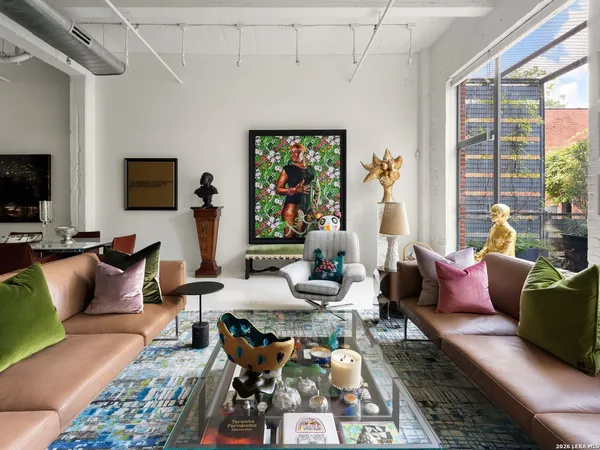 a living room with furniture floor to ceiling window and a flat screen tv