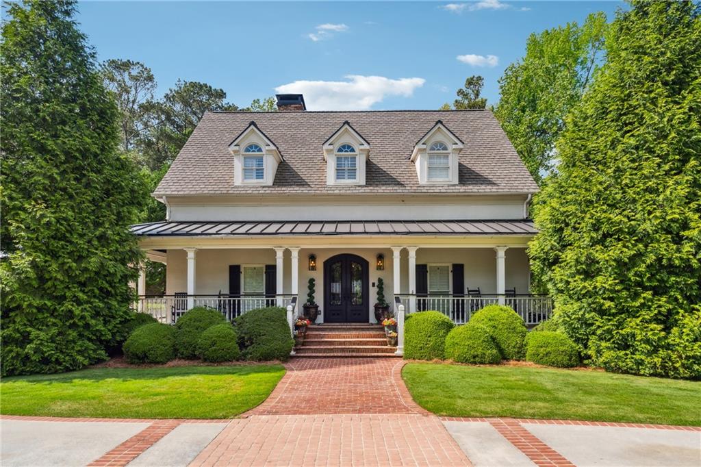 a view of a house with a yard and potted plants