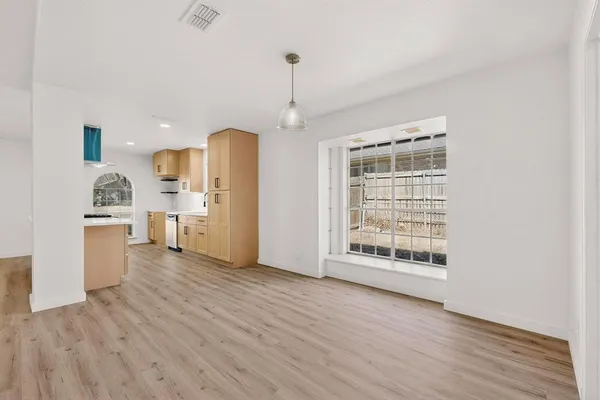a view of a kitchen with a sink dishwasher cabinets and a wooden floor