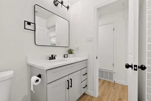 a bathroom with a sink a toilet and shower