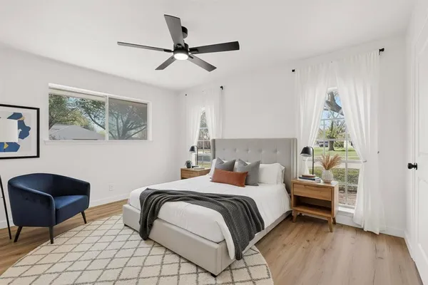 a bedroom with a bed a chair and a potted plant