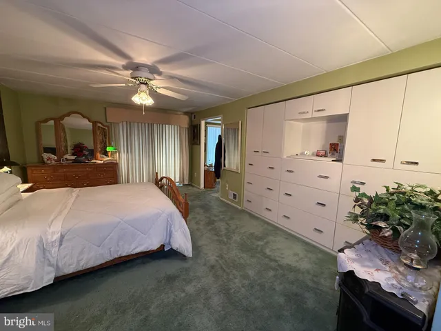 a spacious bedroom with a bed and a dresser