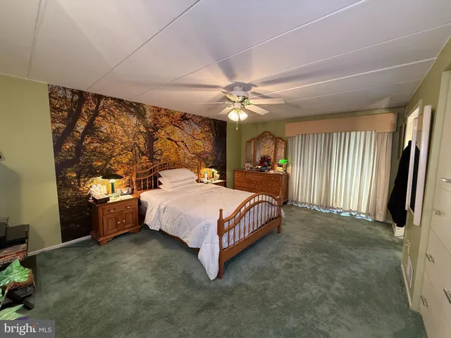 a spacious bedroom with a large bed and a chandelier