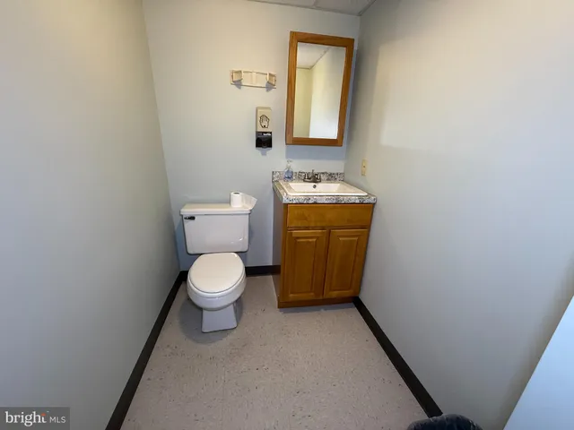a bathroom with a toilet a sink and a mirror