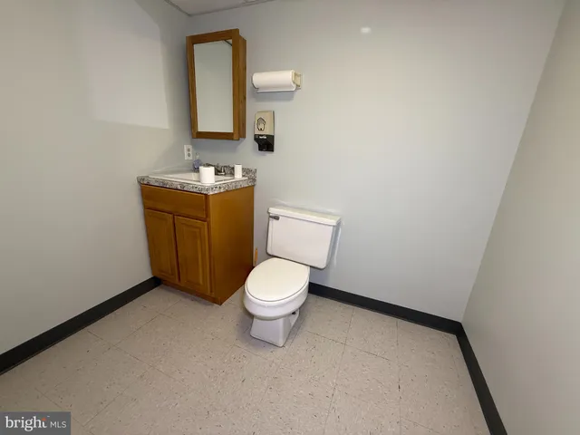 a bathroom with a toilet sink vanity and mirror