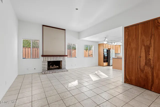 a view of an empty room with a fireplace and a window