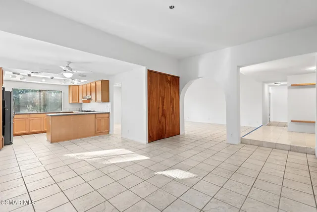 a view of a kitchen with furniture and an empty room