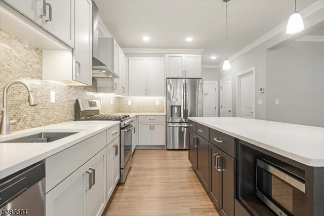 a kitchen with white cabinets sink and stainless steel appliances