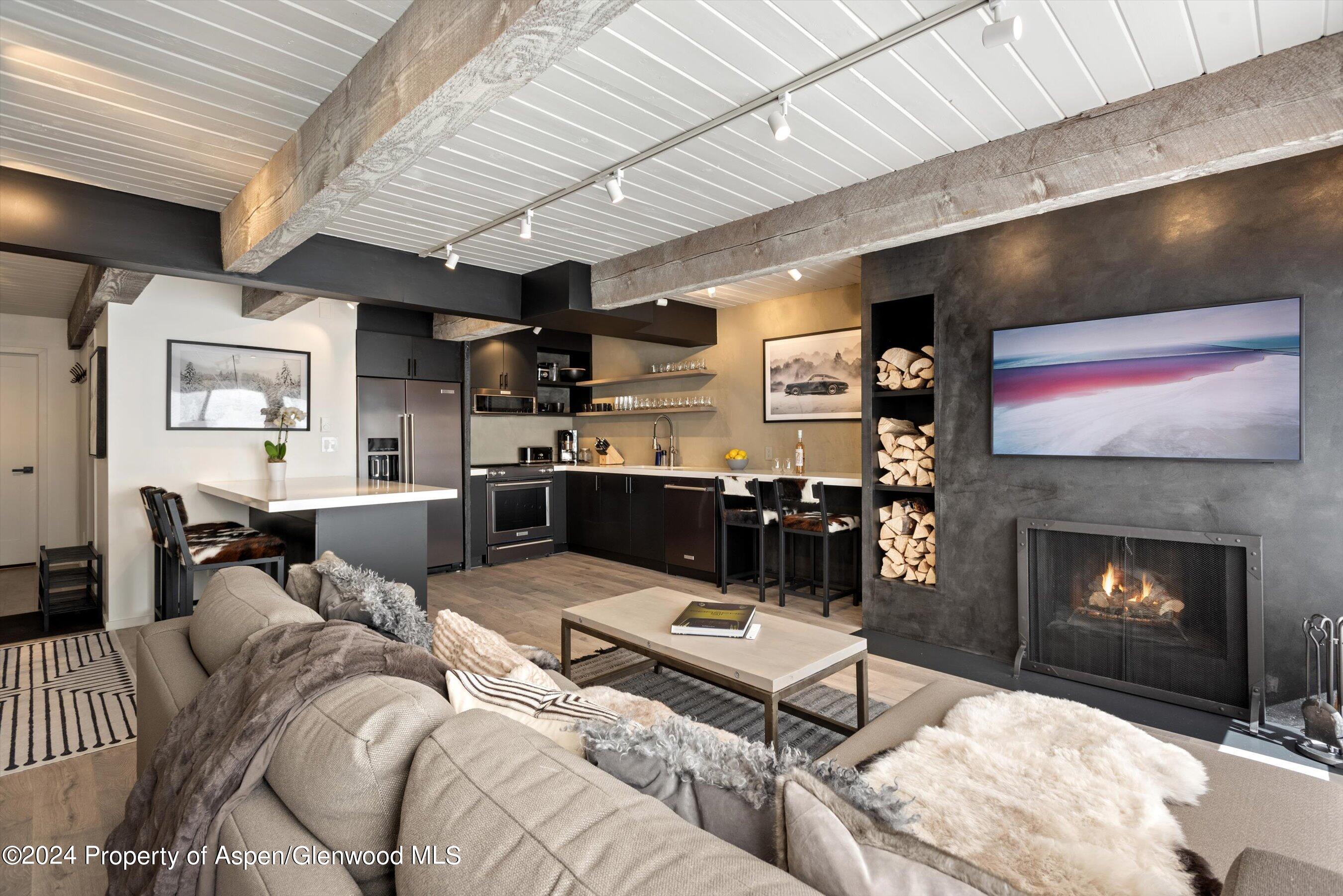 1039 East Cooper Avenue, Unit 19B Aspen, CO 81611 - Photo 1 of 13 a living room with furniture and a fireplace