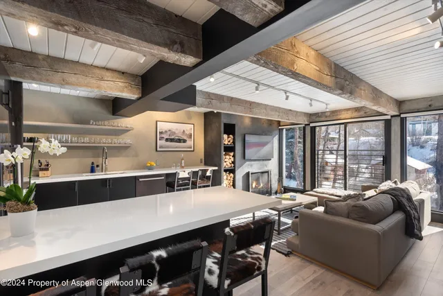 a large living room with stainless steel appliances kitchen island granite countertop furniture and a large window