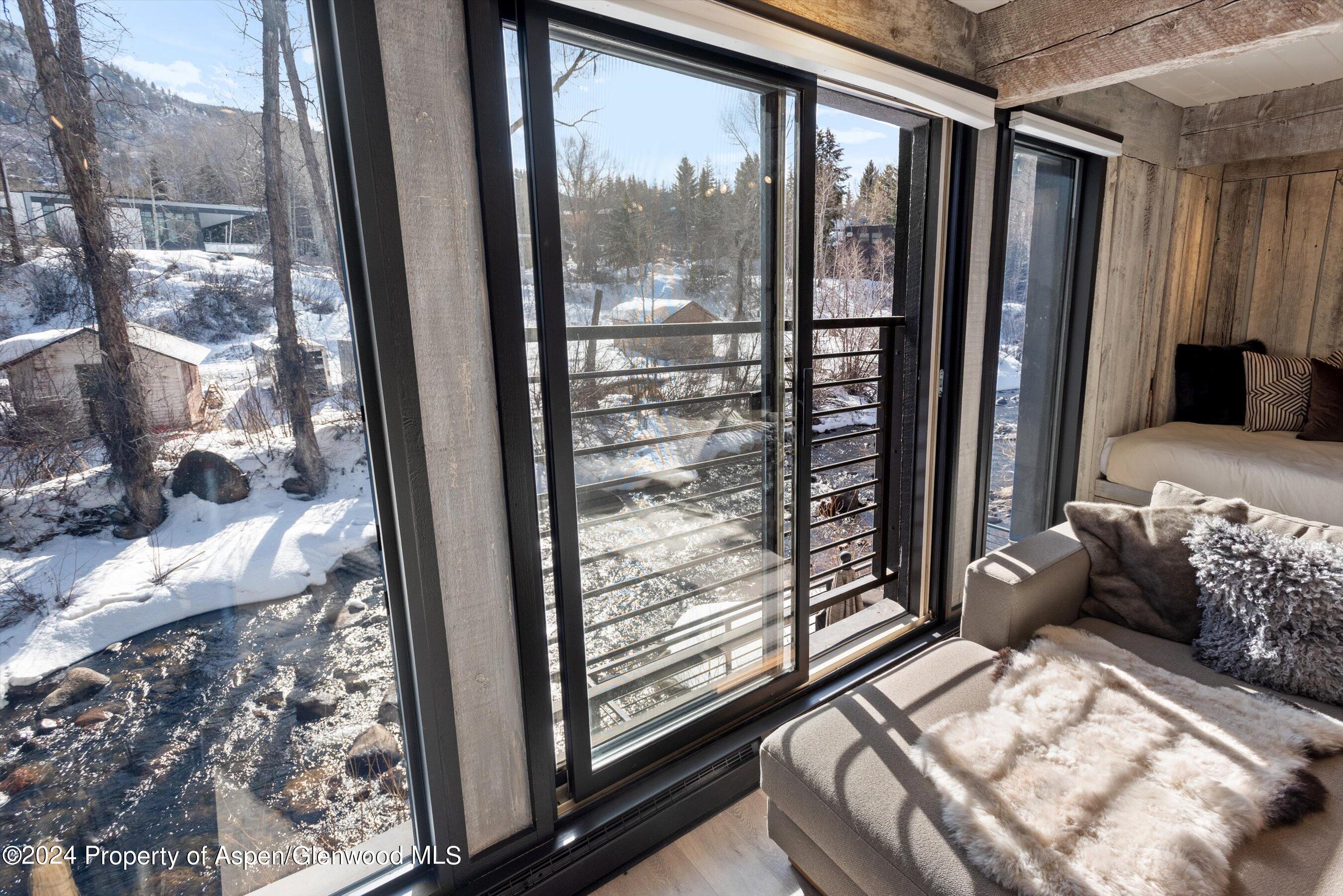 1039 East Cooper Avenue, Unit 19B Aspen, CO 81611 - Photo 5 of 13 a bedroom with a bed and a large window