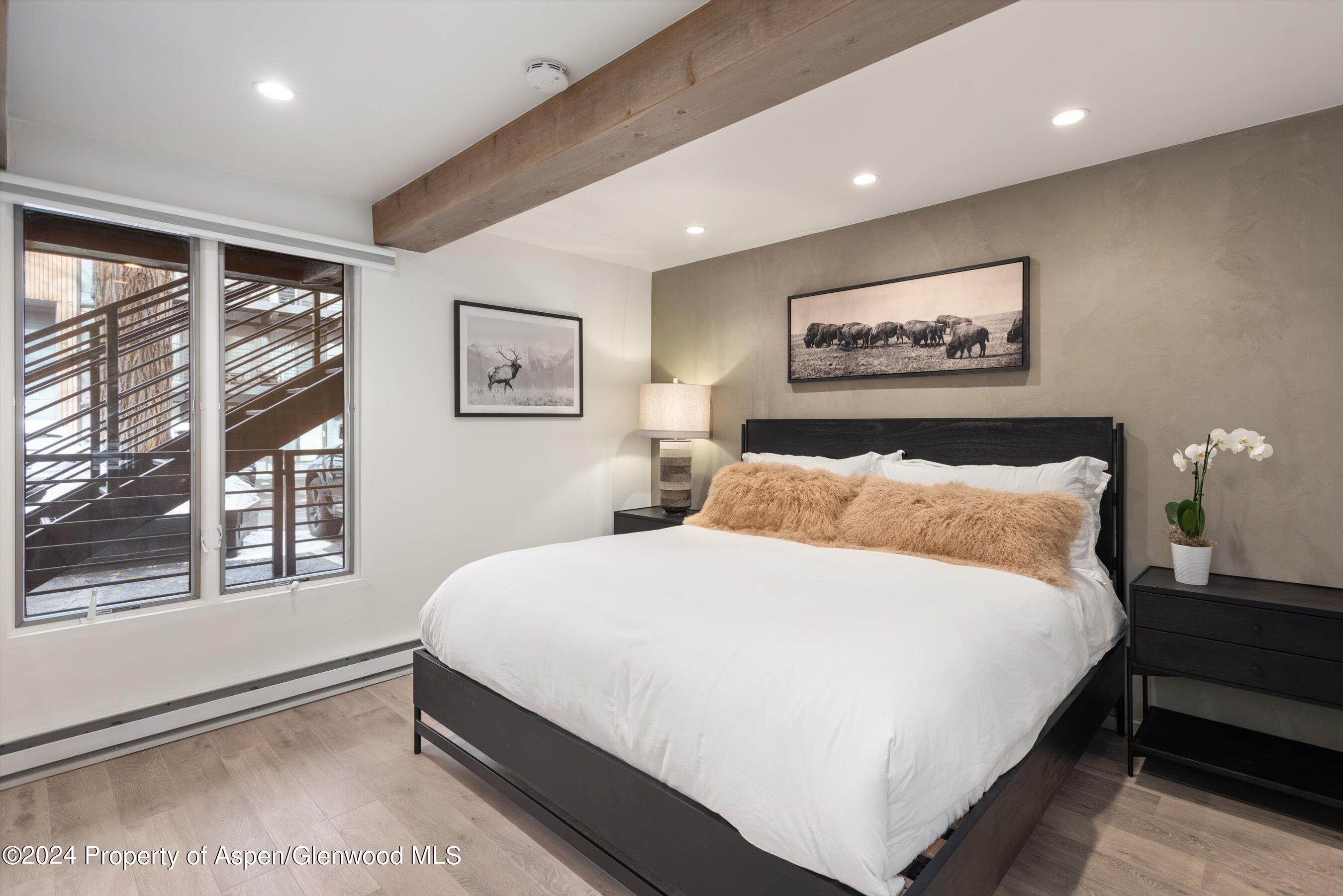 1039 East Cooper Avenue, Unit 19B Aspen, CO 81611 - Photo 9 of 13 a bedroom with a bed and a large window