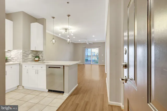 a large white kitchen with a sink a stove a refrigerator and white cabinets