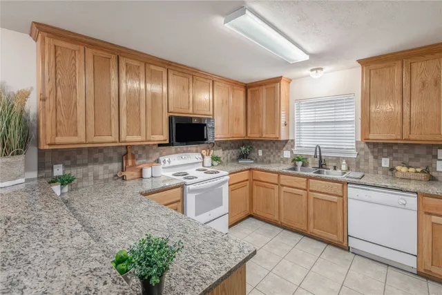 a kitchen with stainless steel appliances granite countertop wooden cabinets a sink and dishwasher