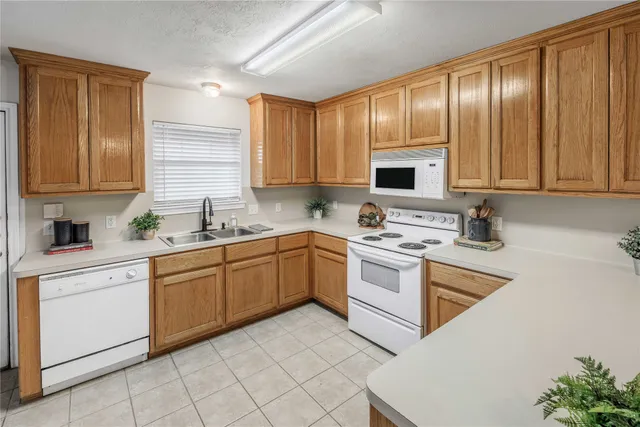 a kitchen with cabinets appliances a sink and a window