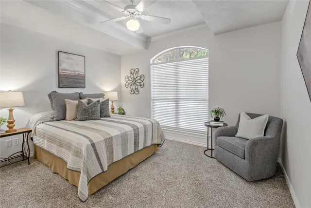 a spacious bedroom with a bed and a chandelier
