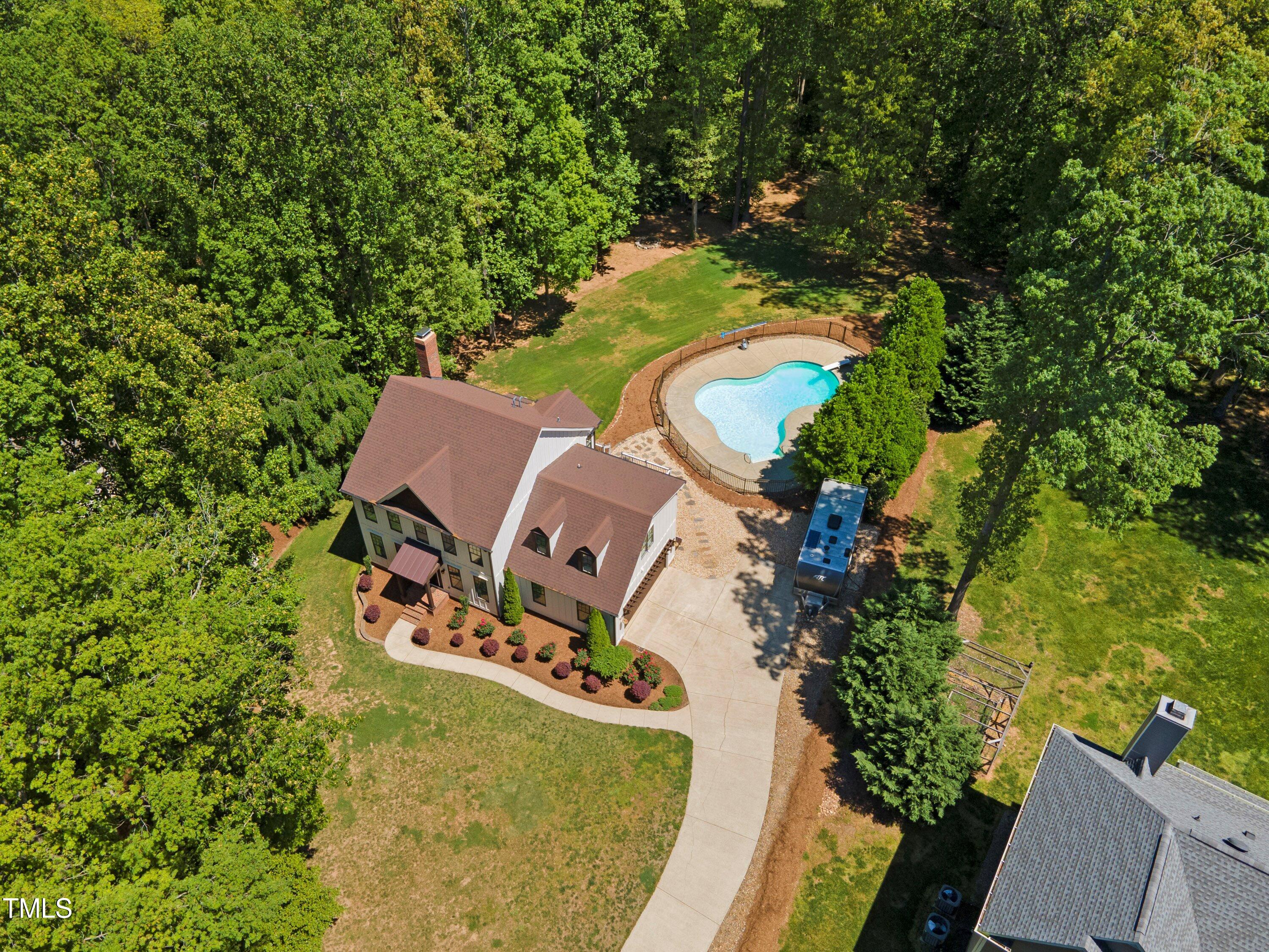 an aerial view of a house with a yard and trees