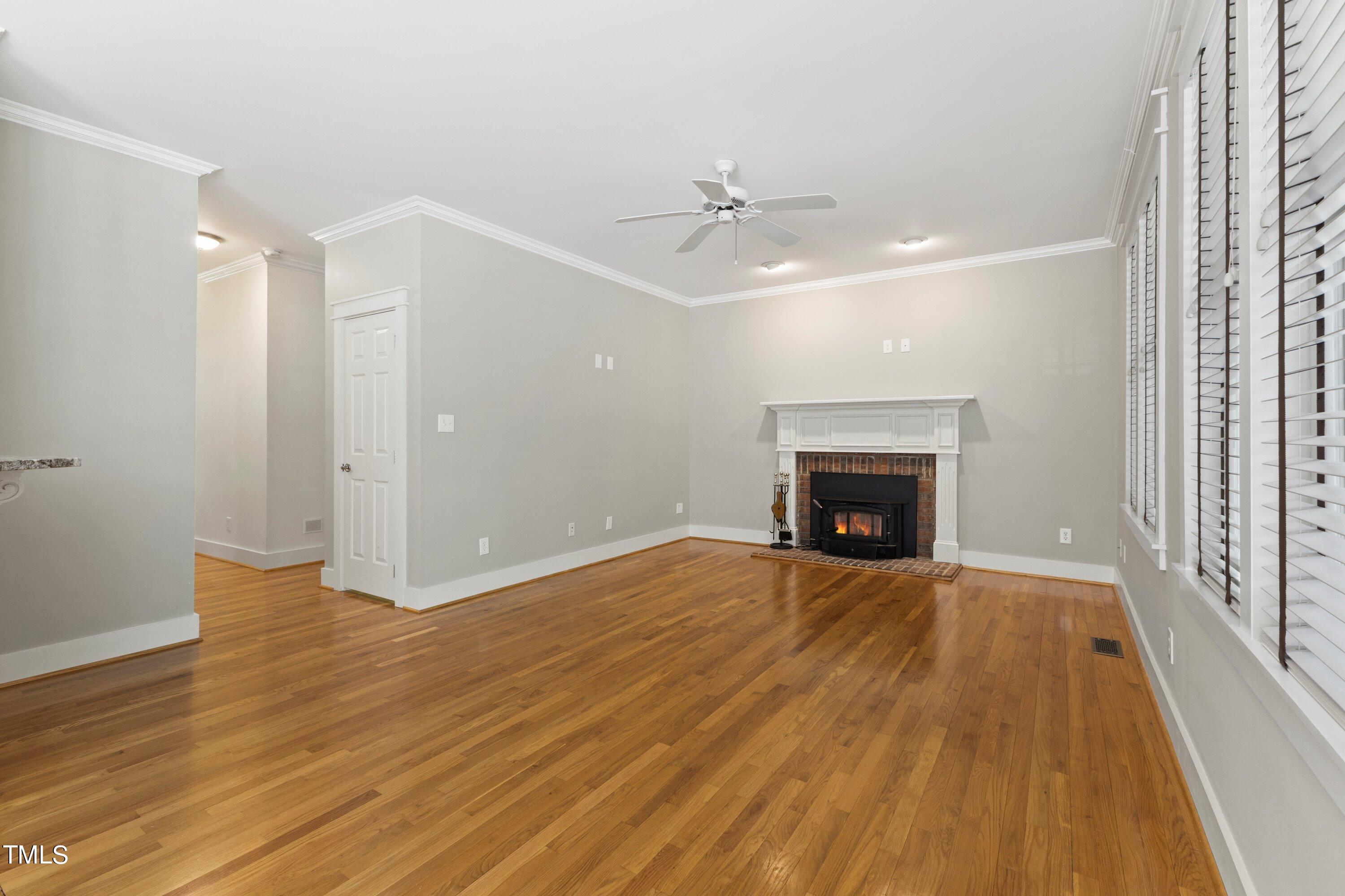 7408 Lakefall Drive Wake Forest, NC 27587 - Photo 15 of 65 a view of empty room with wooden floor and fireplace