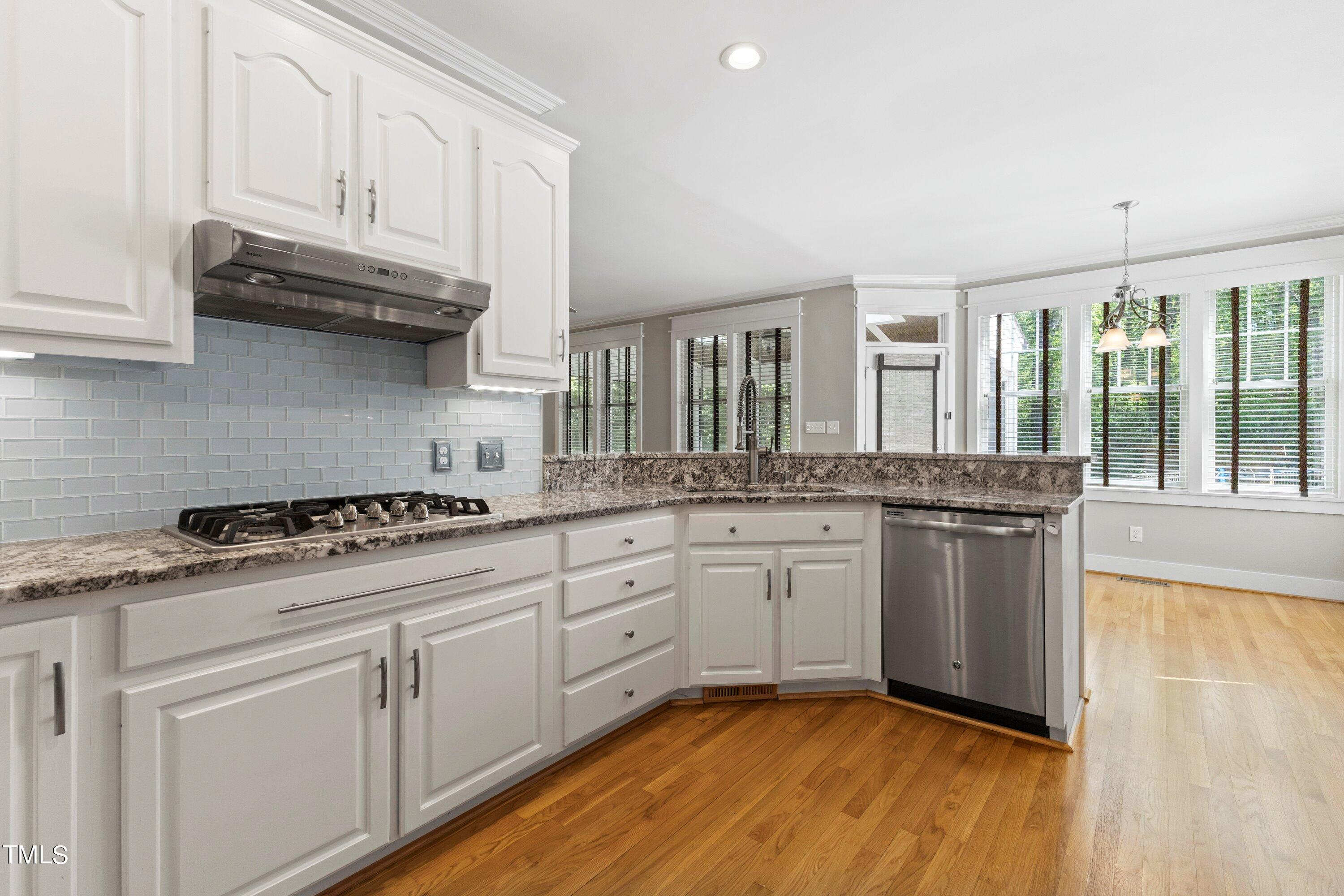 7408 Lakefall Drive Wake Forest, NC 27587 - Photo 22 of 65 a kitchen with granite countertop cabinets stainless steel appliances and a wooden floor