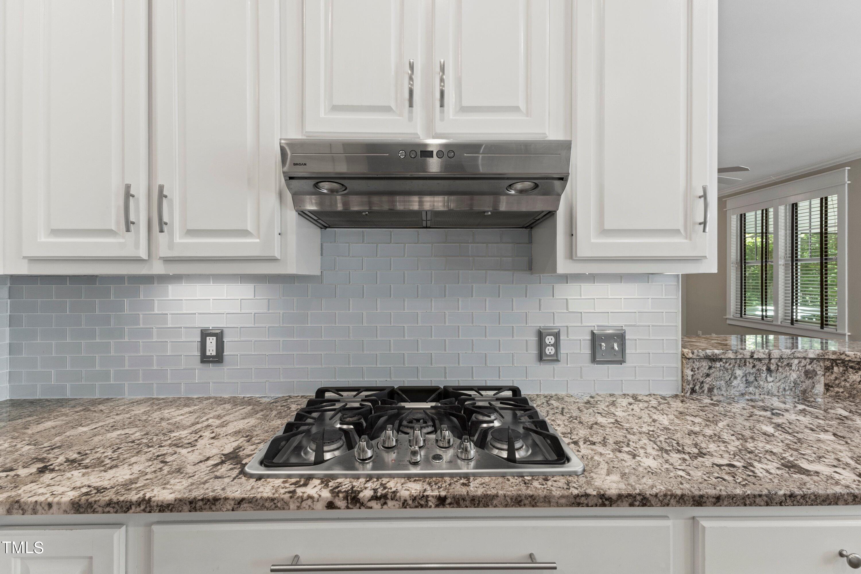7408 Lakefall Drive Wake Forest, NC 27587 - Photo 23 of 65 a kitchen with granite countertop white cabinets and a stove