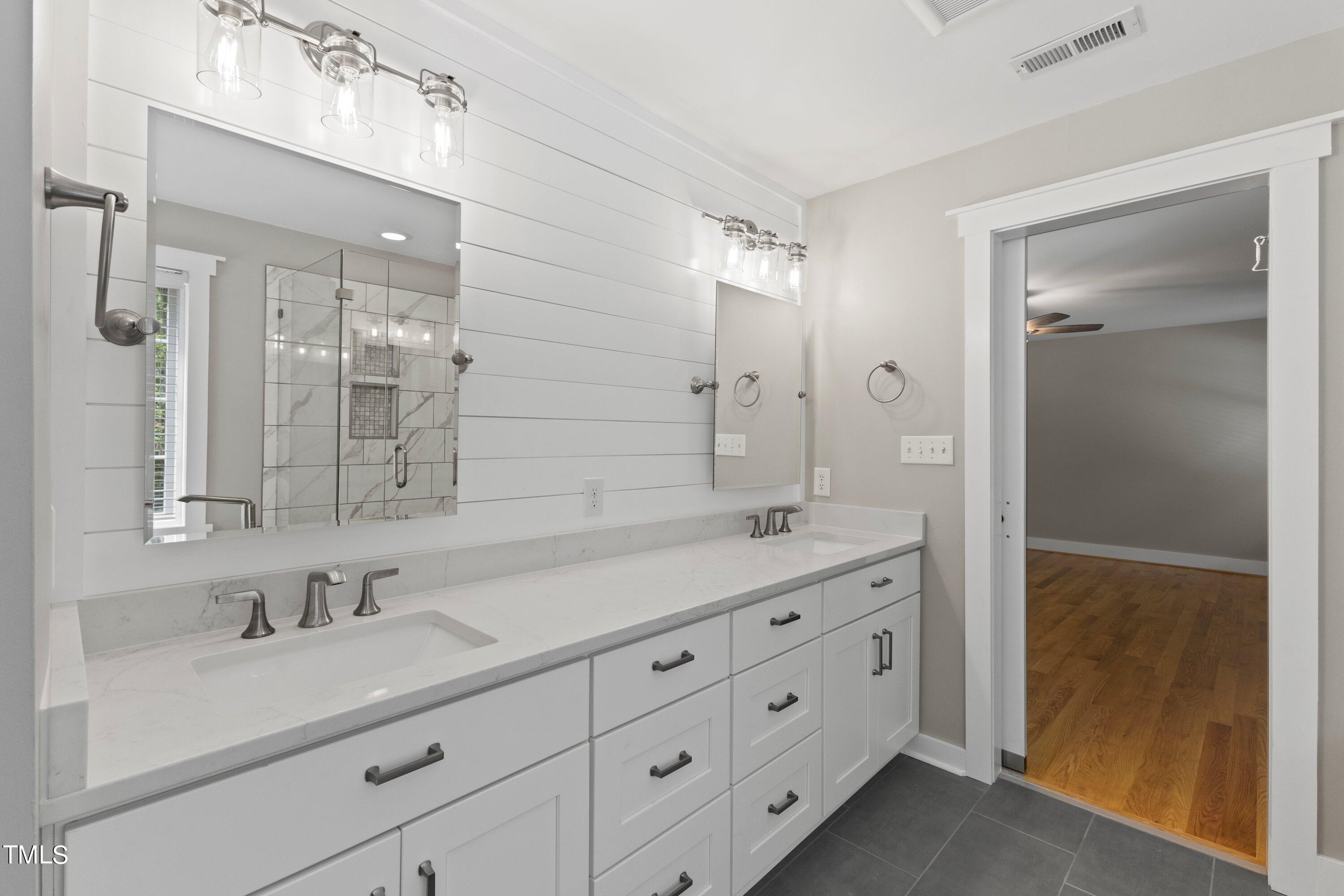 7408 Lakefall Drive Wake Forest, NC 27587 - Photo 32 of 65 a bathroom with double sink and mirror