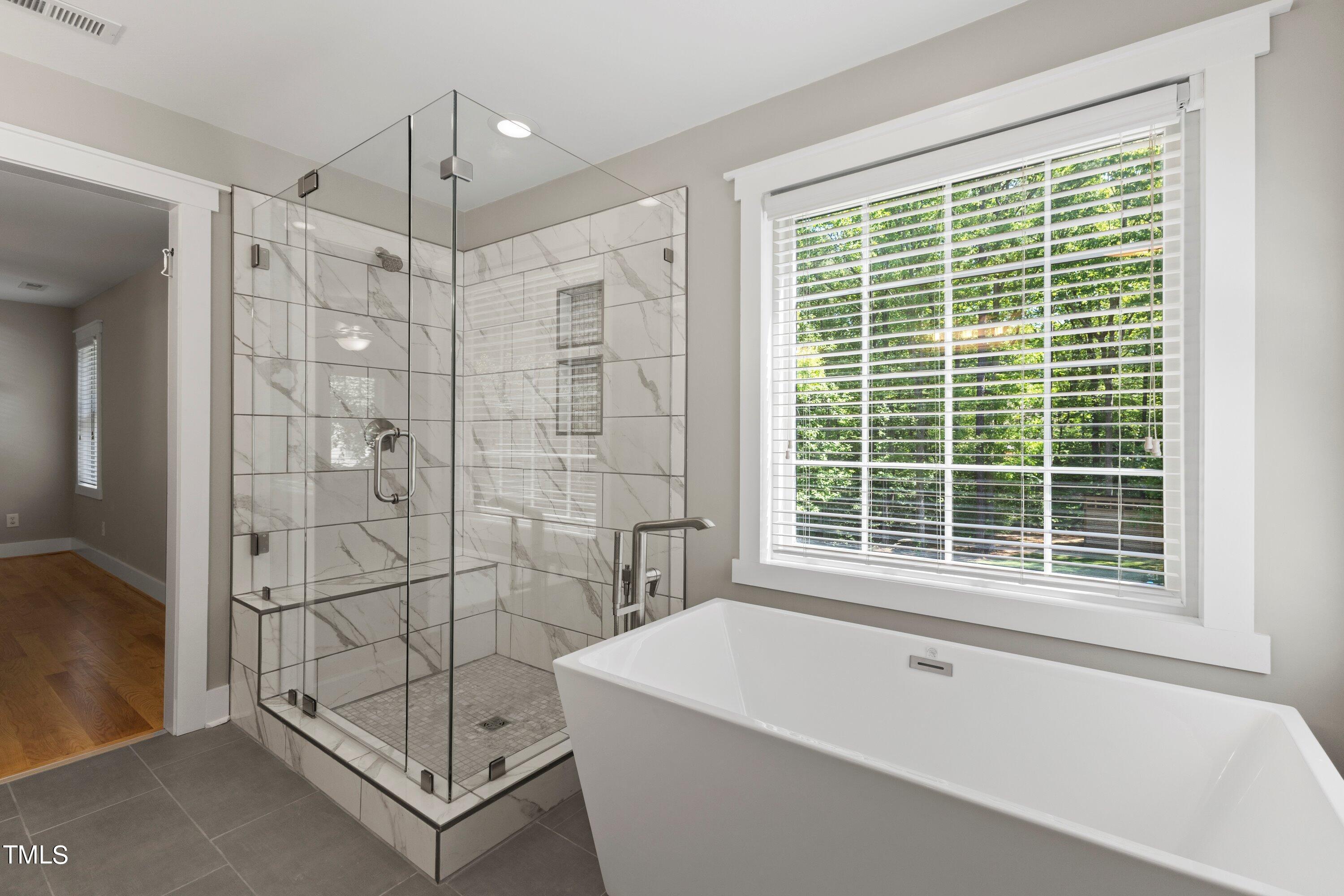 7408 Lakefall Drive Wake Forest, NC 27587 - Photo 33 of 65 a bathroom with a bathtub a shower and a window