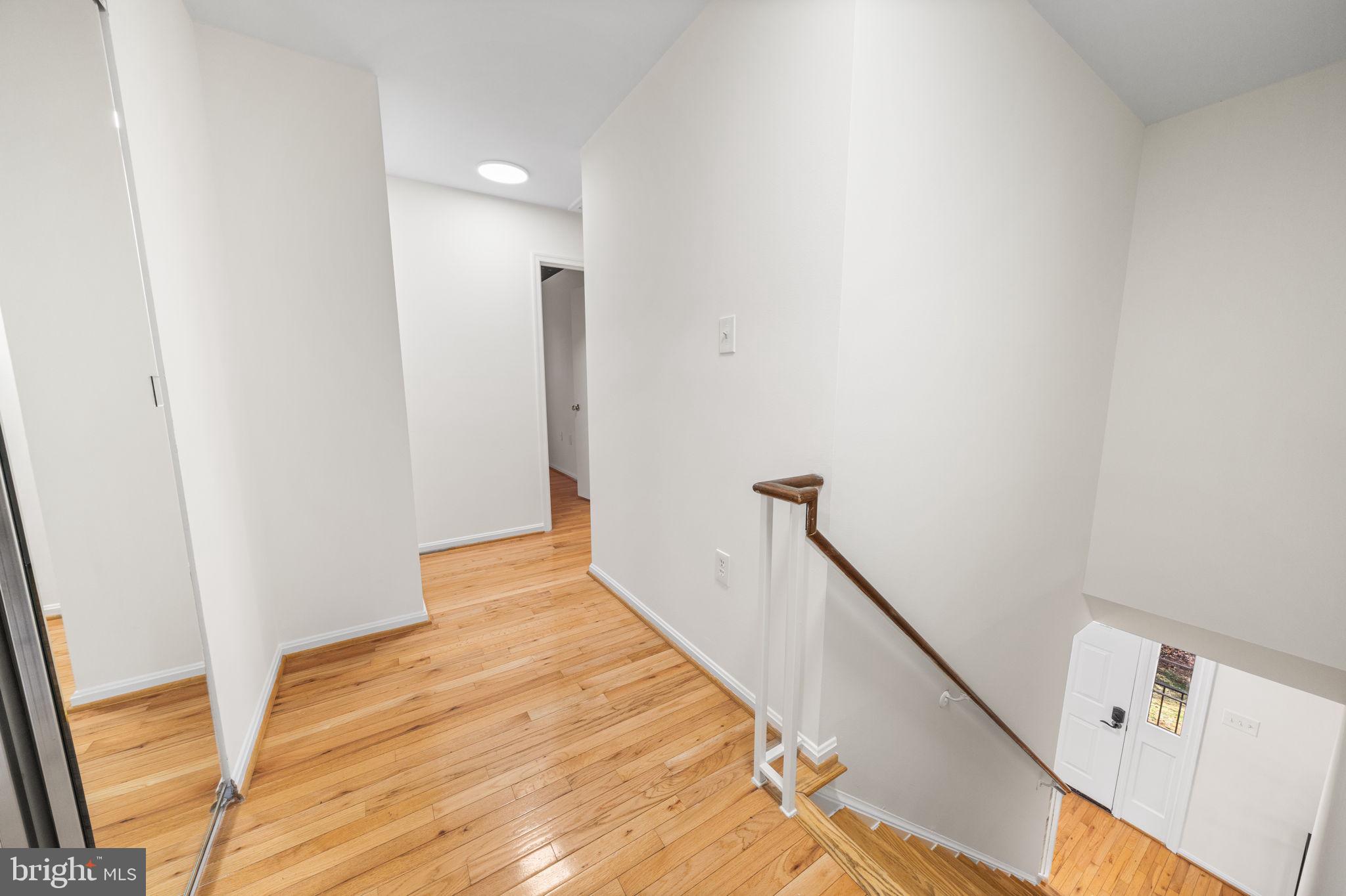 5658 Sutherland Court Burke, VA 22015 - Photo 12 of 30 a view of a hallway with wooden floor and staircase