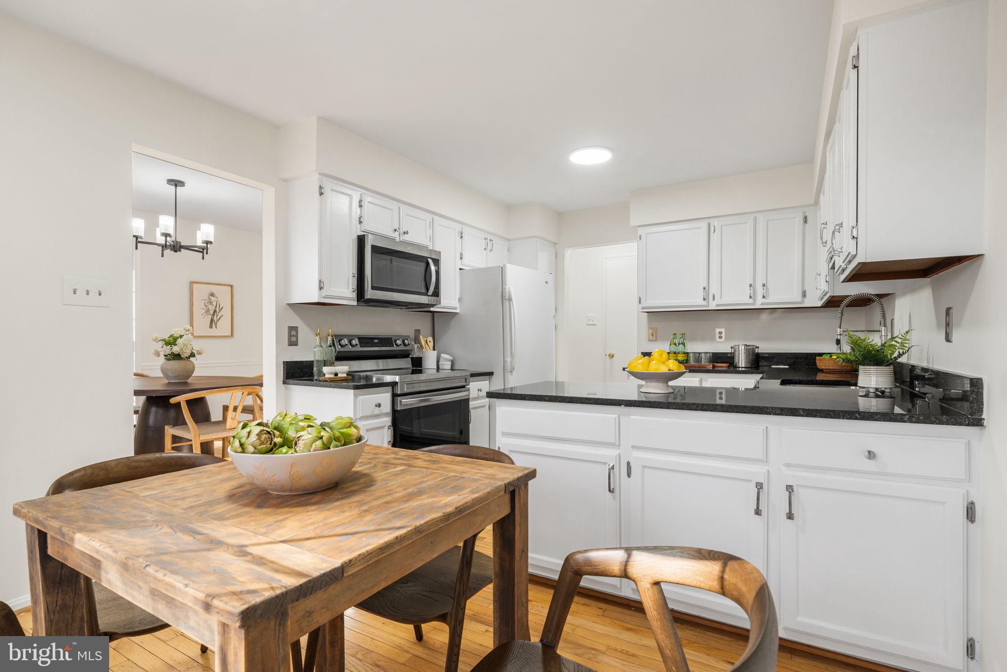 5658 Sutherland Court Burke, VA 22015 - Photo 8 of 30 a kitchen with granite countertop kitchen island a table and chairs
