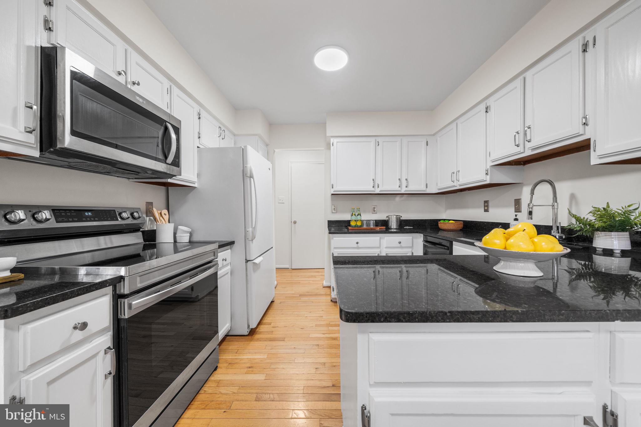 5658 Sutherland Court Burke, VA 22015 - Photo 9 of 30 a kitchen with stainless steel appliances granite countertop a stove sink microwave and cabinets