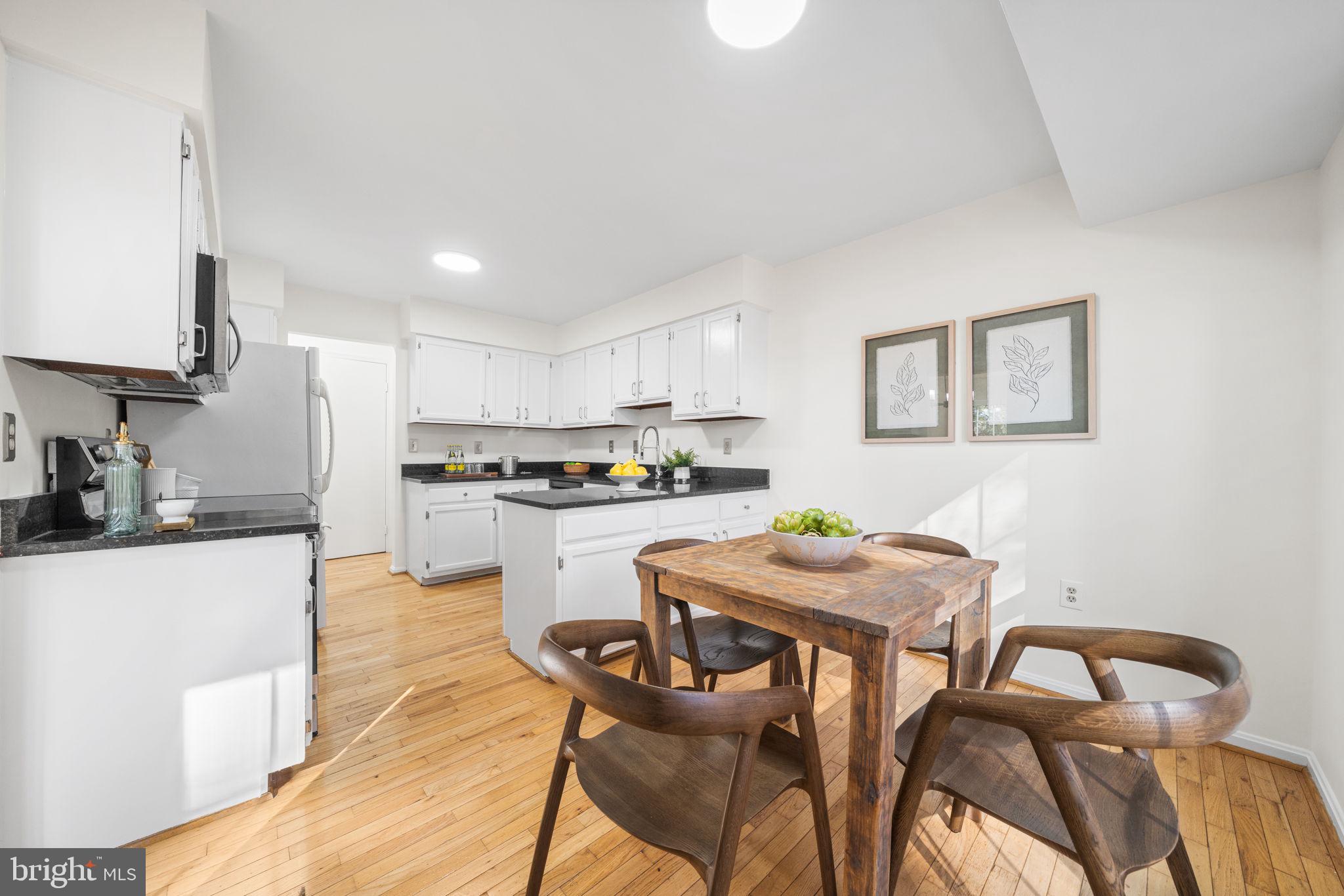 5658 Sutherland Court Burke, VA 22015 - Photo 10 of 30 a kitchen with stainless steel appliances kitchen island granite countertop a dining table chairs and a refrigerator