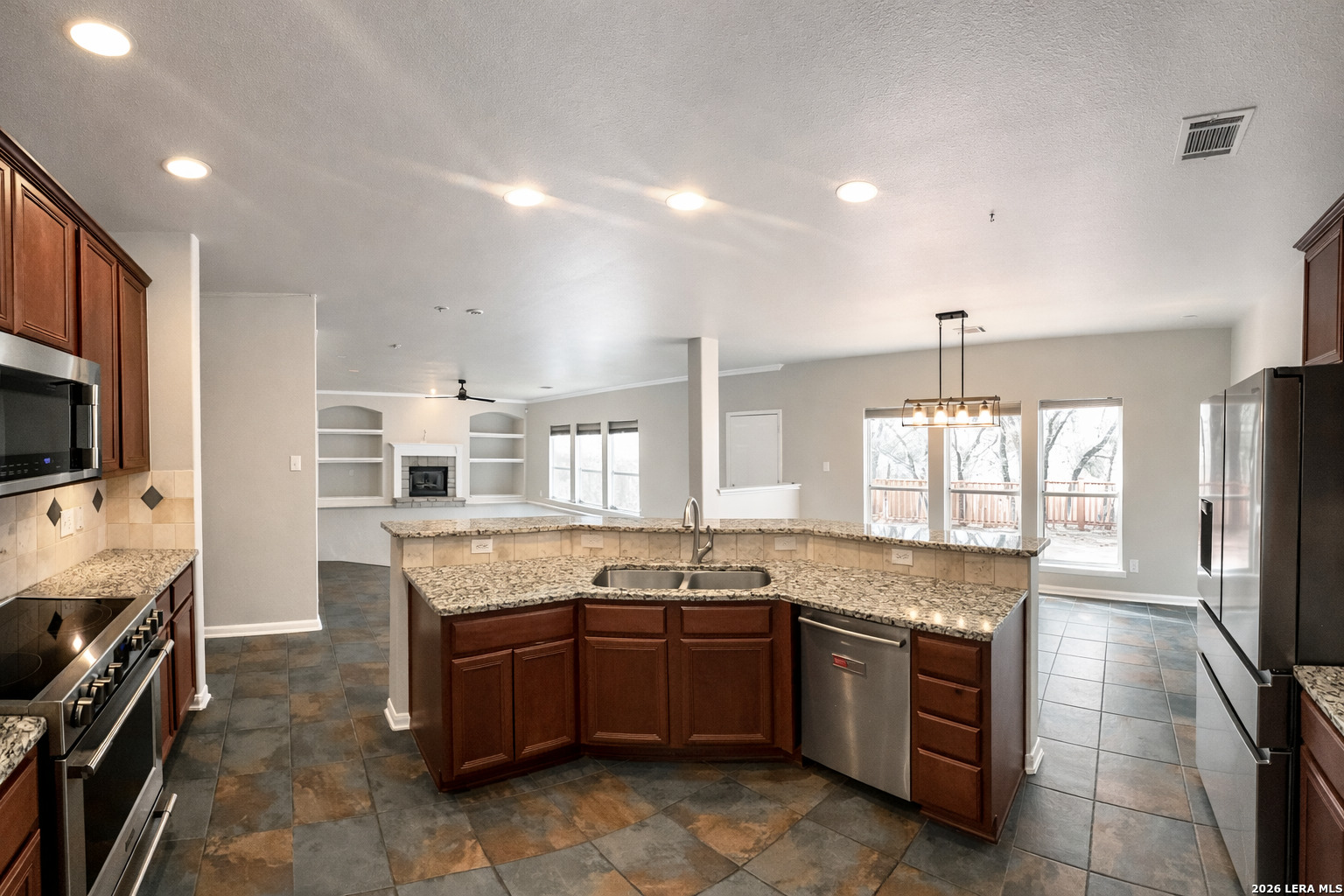 15603 Luna Ridge Helotes, TX 78023 - Photo 19 of 24 a large kitchen with granite countertop a stove and a sink