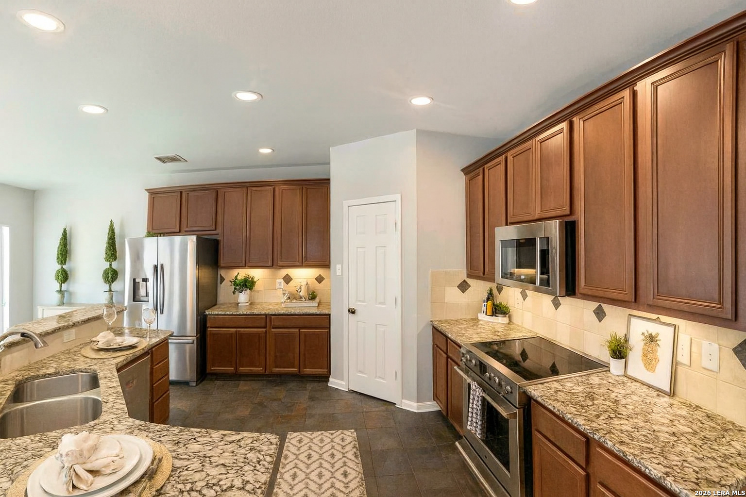 15603 Luna Ridge Helotes, TX 78023 - Photo 5 of 24 a kitchen with stainless steel appliances granite countertop a sink stove and refrigerator