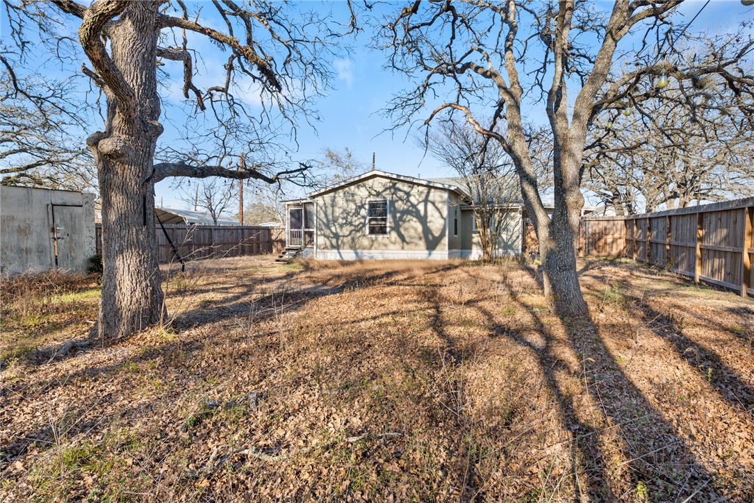 1014 Suncrest Street Bryan, TX 77803 - Photo 13 of 20 Back of property featuring a fenced backyard and an outbuilding