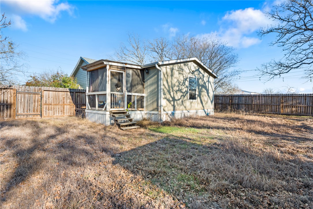 1014 Suncrest Street Bryan, TX 77803 - Photo 15 of 20 Back of property with a sunroom and a fenced backyard