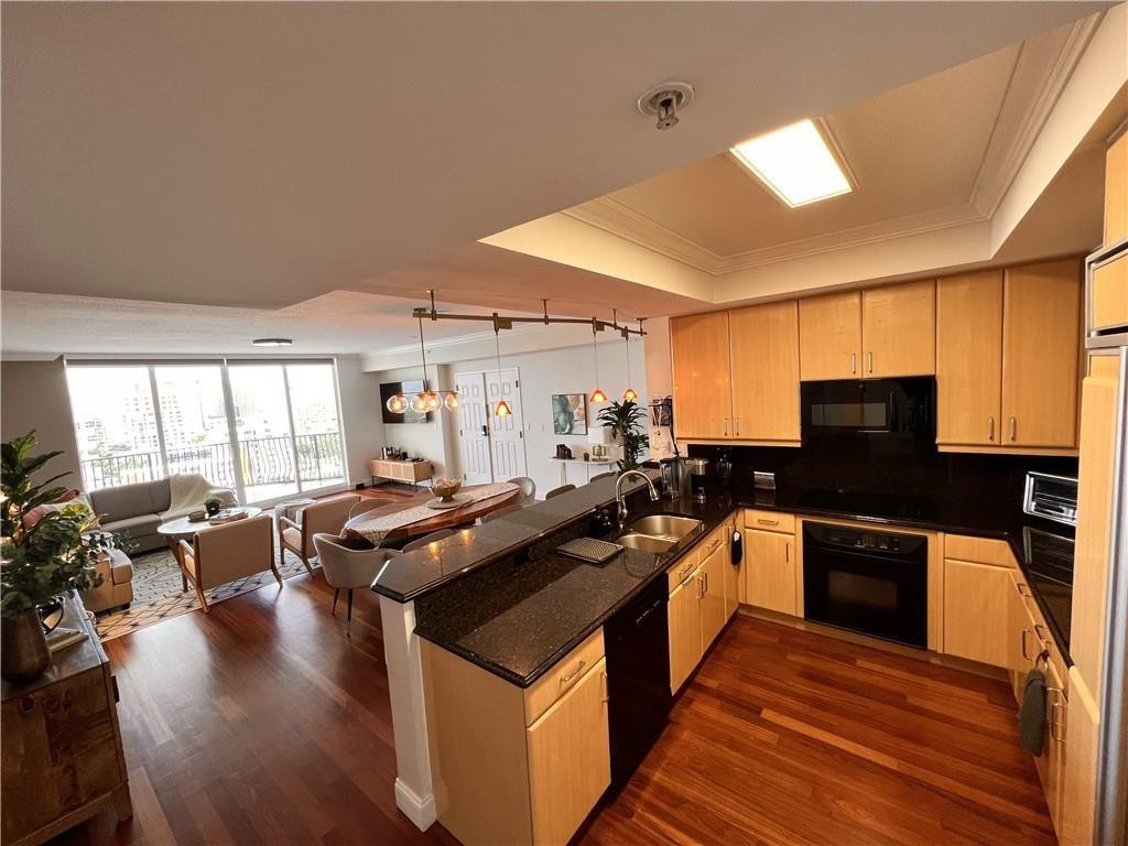 100 South Birch Road, Unit 1403F Fort Lauderdale, FL 33316 - Photo 15 of 31 a kitchen with stainless steel appliances granite countertop a stove top oven a sink dishwasher a dining table and chairs with wooden floor